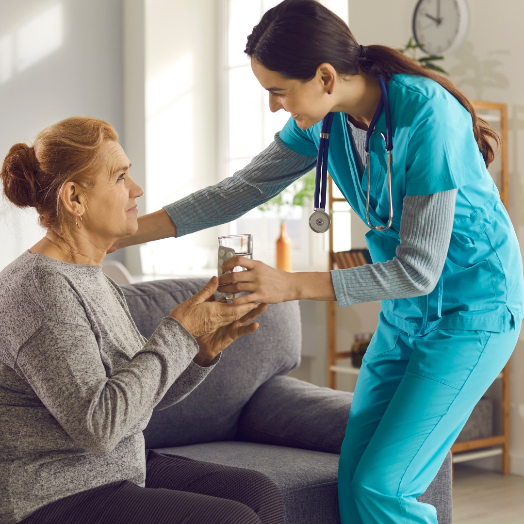 nurse giving elderly woman medication