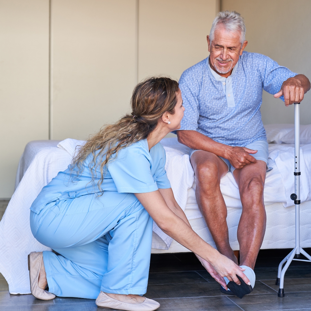 nurse helping senior man dress
