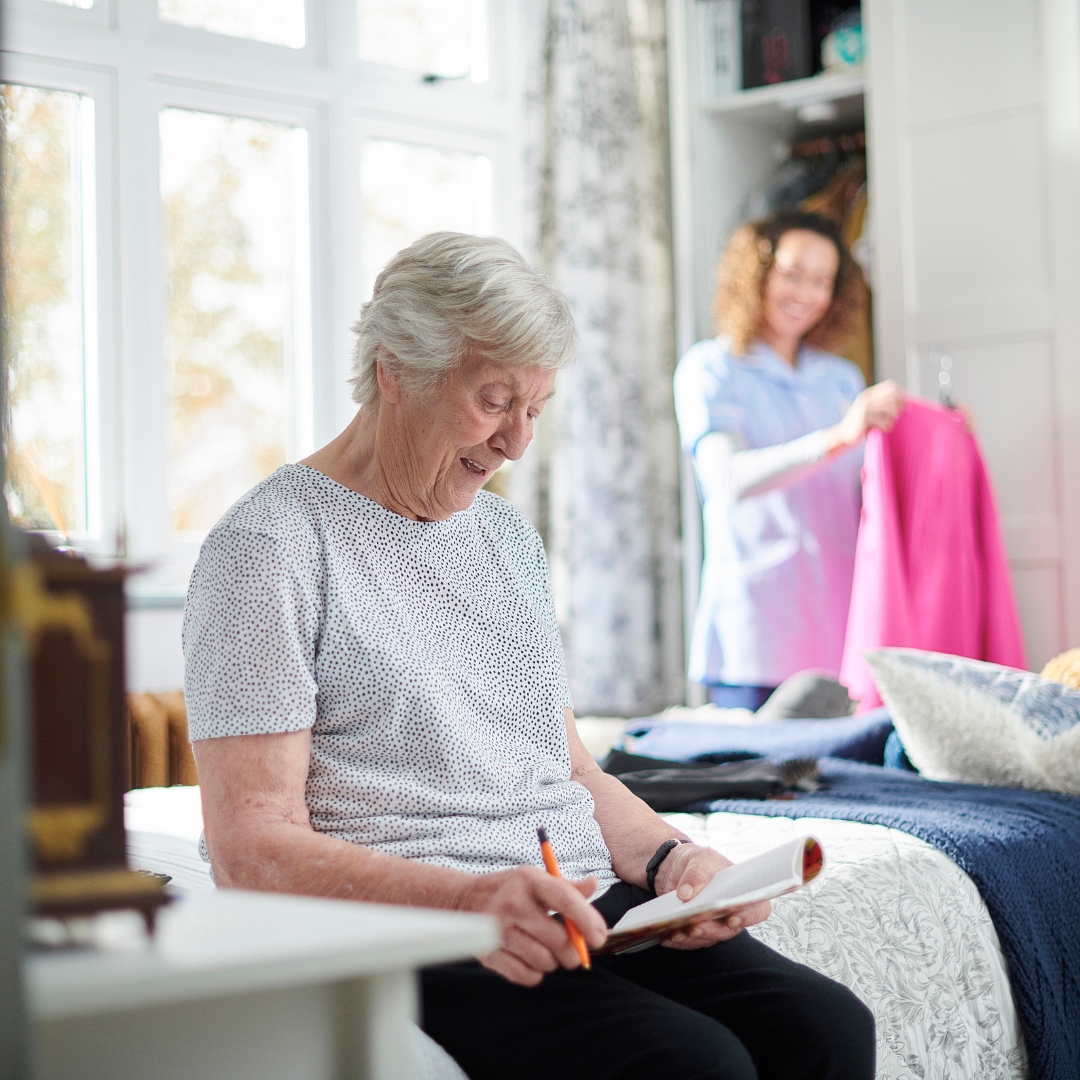 woman cleaning and putting away clothes for elderly woman