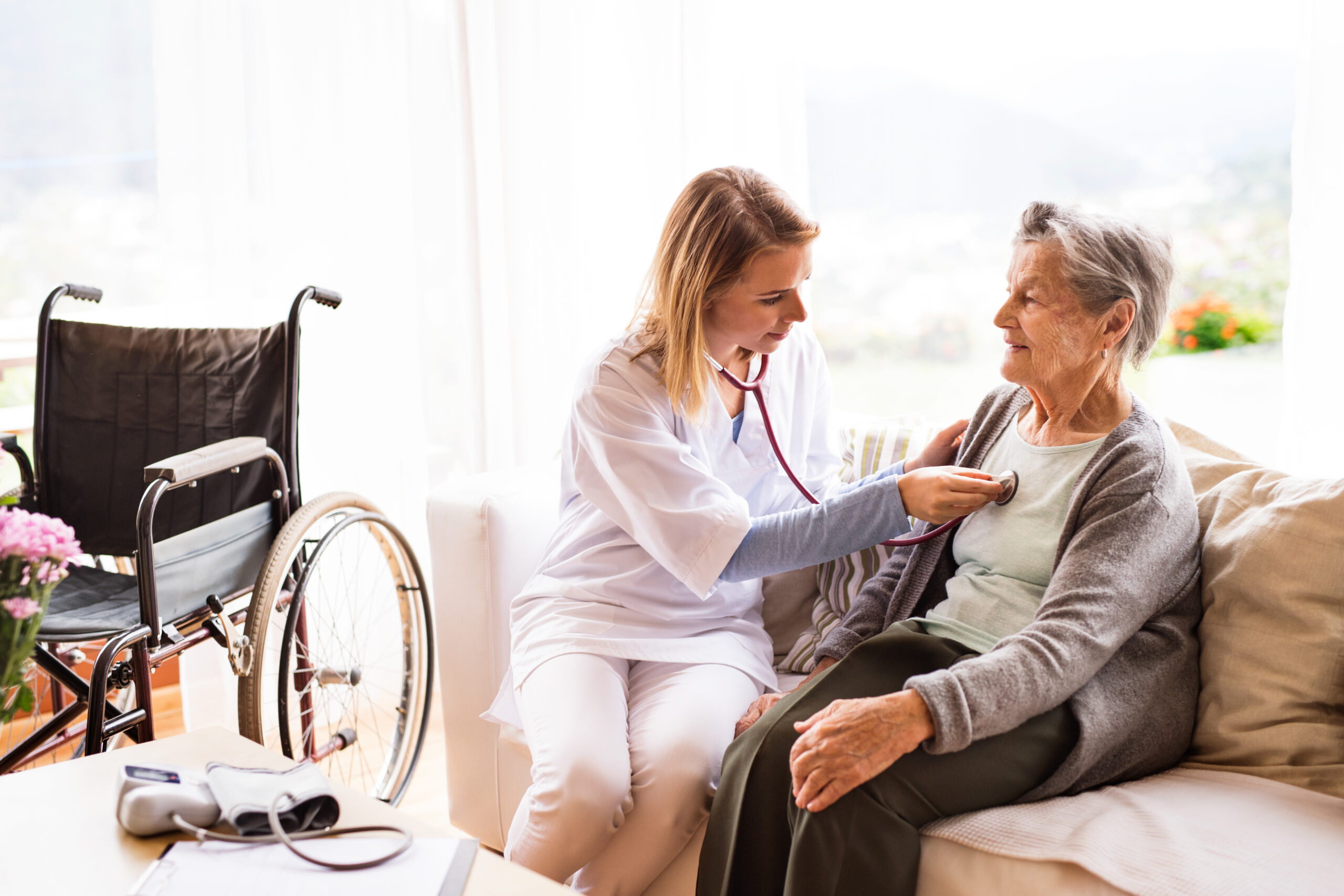 Health visitor and a senior woman during home visit. A nurse or a doctor examining a woman.