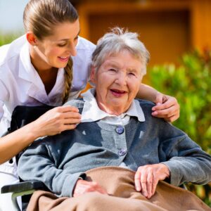 close up of a nurse smiling with a senior resident in a wheelchair