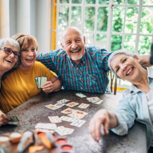 group of senior friends playing cards