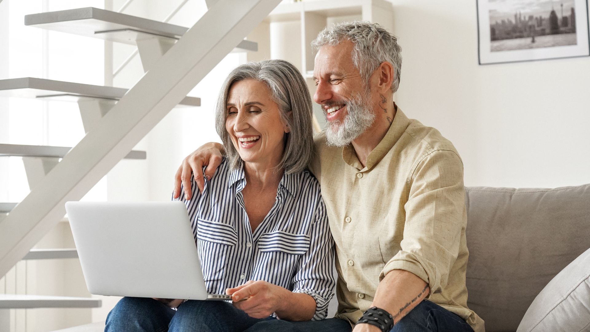 happy senoir couple looking at computer