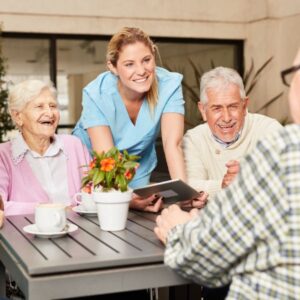 seniors sitting at a table with a nurse