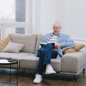 Senior reading a book on his couch