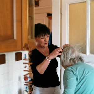 Grown woman helping an elderly woman with her hair