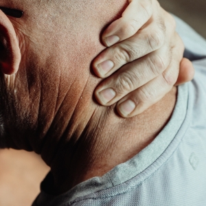 Man holding the back of his neck