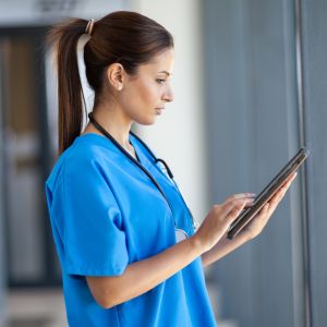 A caregiver looking at an Ipad.