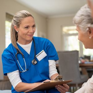 A caregiver talking with a senior couple.