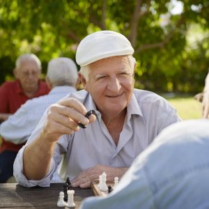 Senior playing chess outdoors.